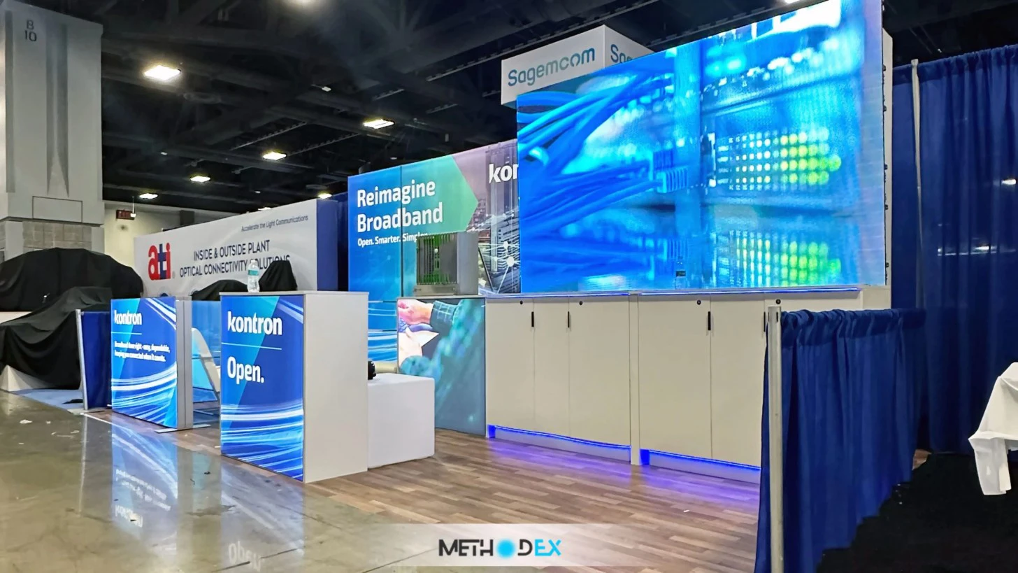 Kontron booth with blue backlit counters, white cabinets with blue base lighting, and a large LED wall showing network cables